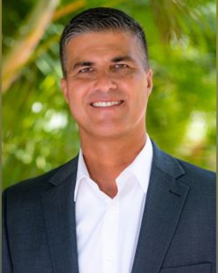 Val Martin, REALTOR with Keller Williams Realty Maui, smiling in a dark suit